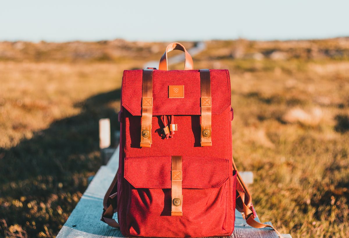 A red backpack left on a park bench, illustrating Firta's lost-and-found service